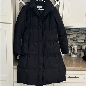 CK black puffer coat. Knee length Duck down filled. Snap closures, high collar.